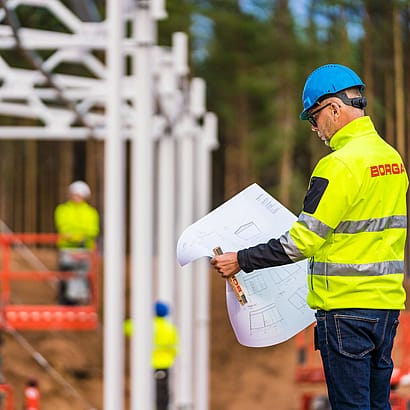Hallbyggare studerar ritning av stålhall
